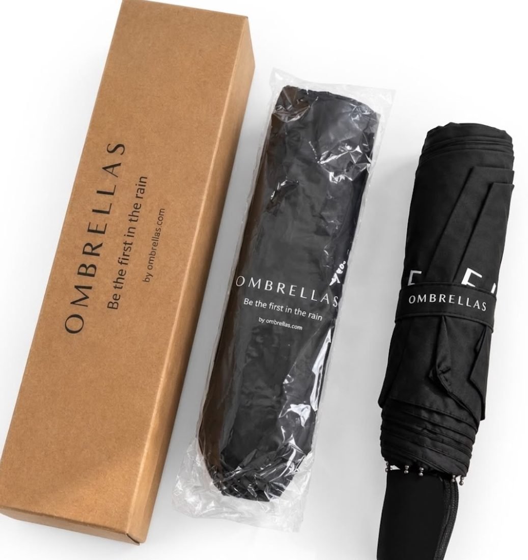 What arrives: the printed kraft gift box, the umbrella in its protective sleeve, and the folded umbrella with its branded band